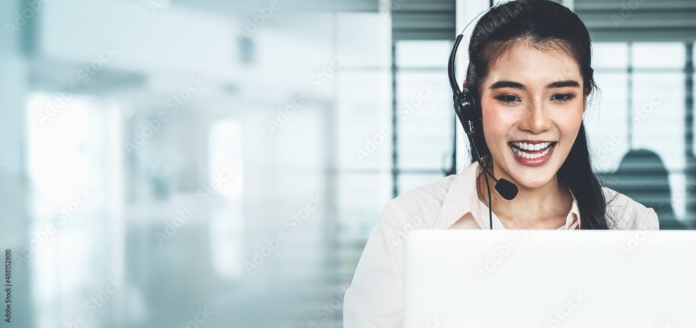 Businesswoman wearing headset working actively in office . Call center, telemarketing, customer supp