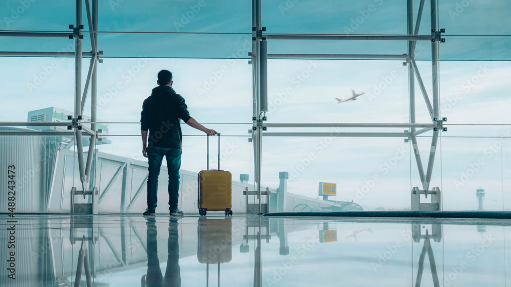 Passenger with baggage at international airport walking to terminal gate - Travel and transportation