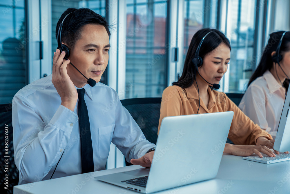 Business people wearing headset working actively in office . Call center, telemarketing, customer su