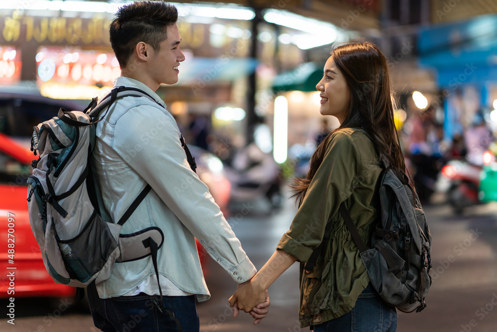 Asian active young couple travel in city for honeymoon trip at night. 