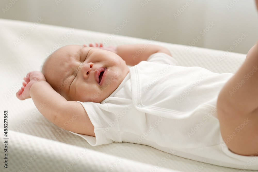 Asian newborn baby crying on baby bed crib