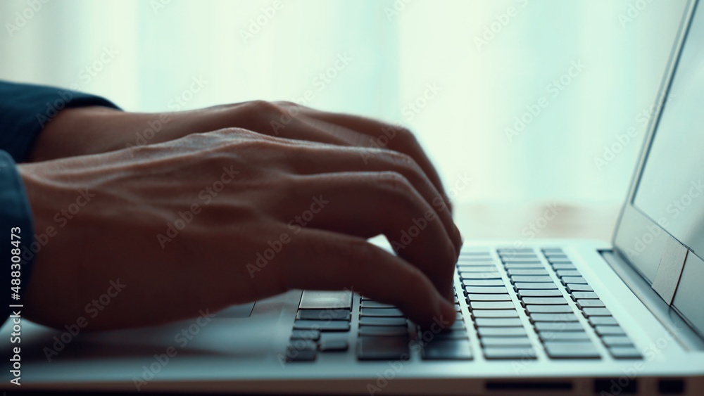 Businessman hand work on capable laptop computer at office table close up shot and selective focus a