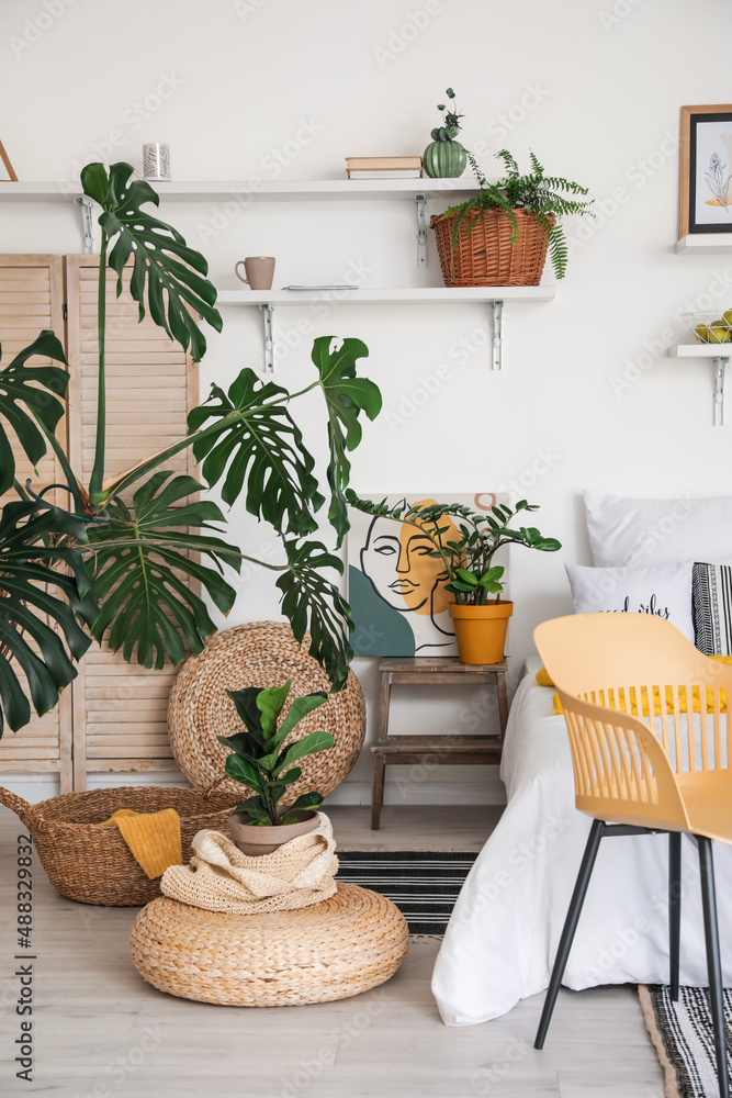 Stylish interior of modern bedroom with houseplants