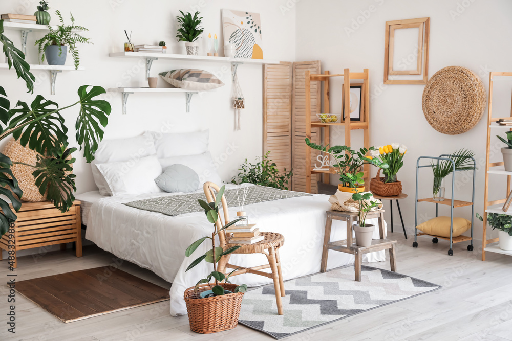 Stylish interior of modern bedroom with houseplants