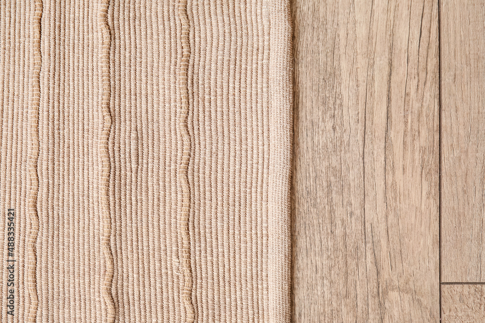 Stylish carpet on wooden floor, closeup