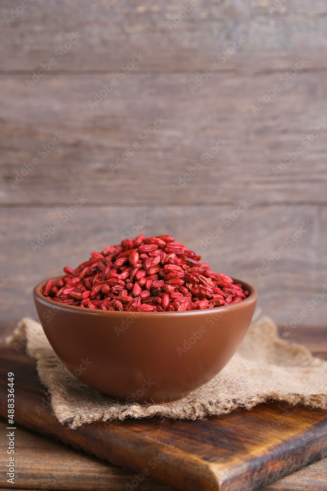 Bowl with dried barberries on wooden background