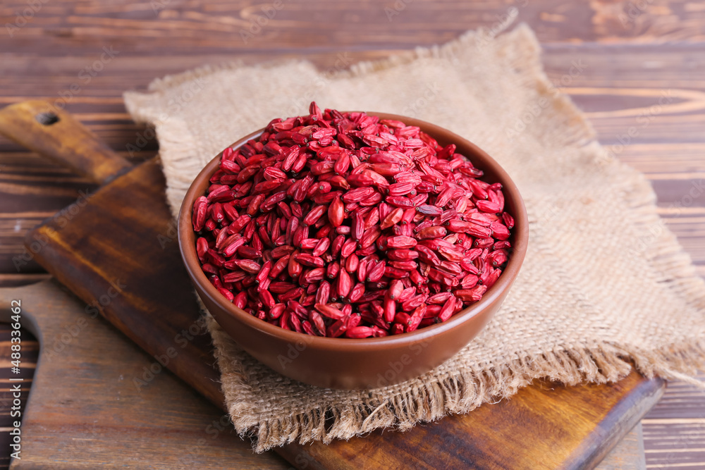 Bowl with dried barberries on wooden background