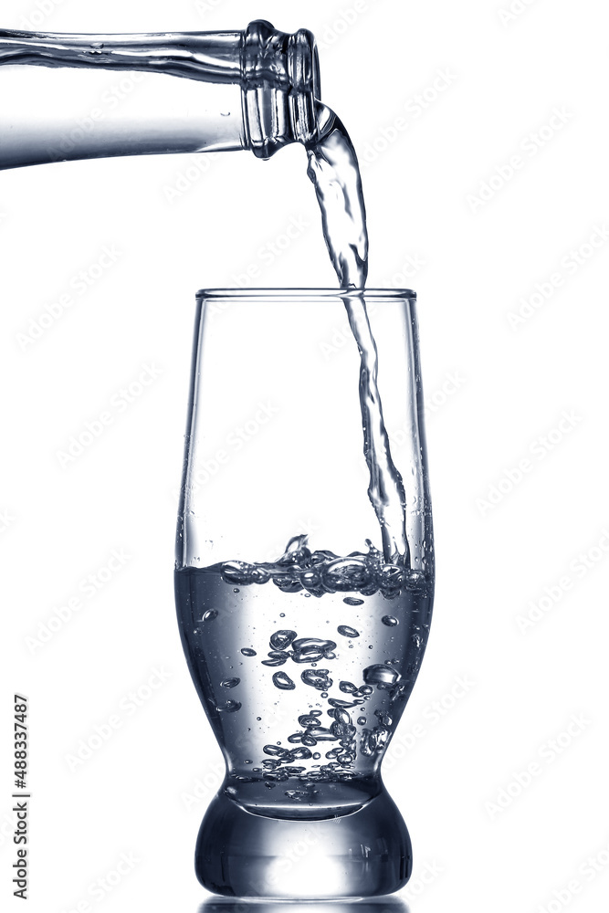 Pouring of clear water in glass isolated on white