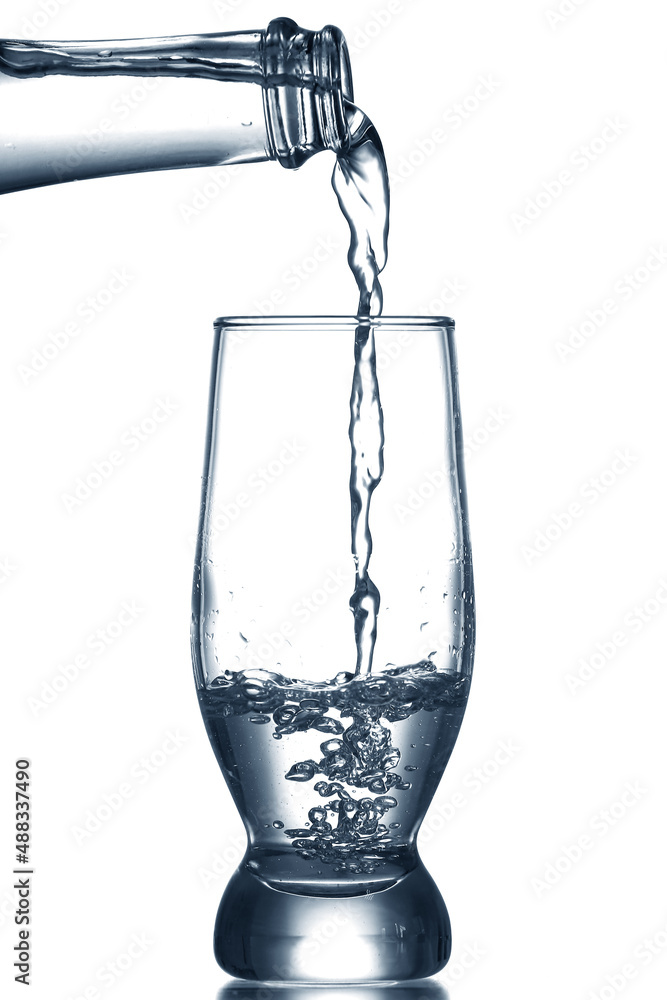 Pouring of clear water in glass isolated on white