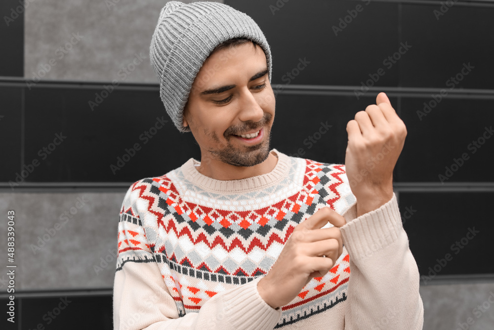 Handsome young man in knitted sweater outdoors