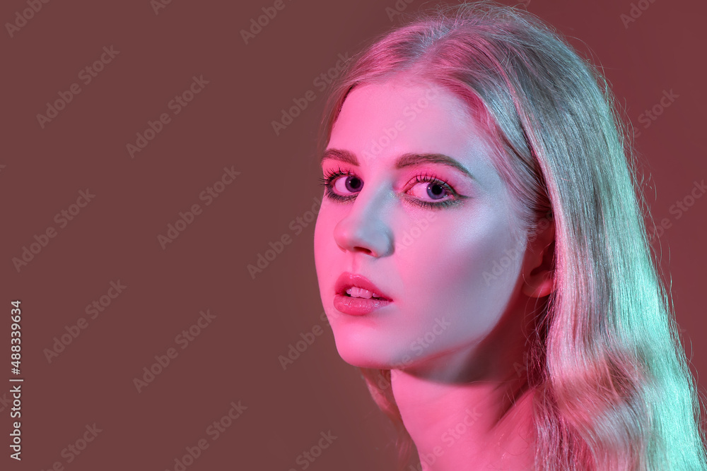 Beautiful girl with stylish makeup on color background