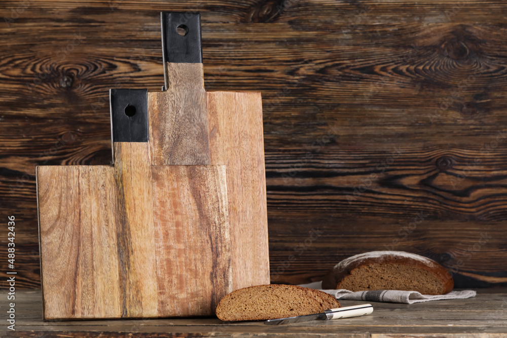 Cutting boards and bread on wooden background