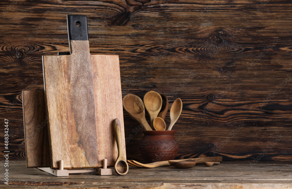 Cutting boards and spoons on wooden background