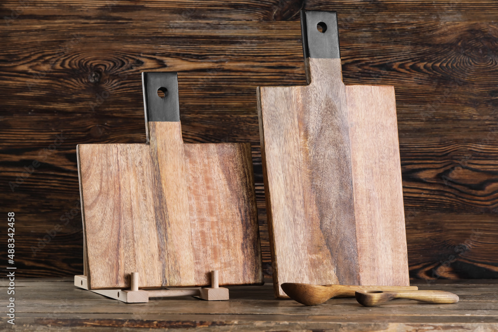 Cutting boards and spoons on wooden background