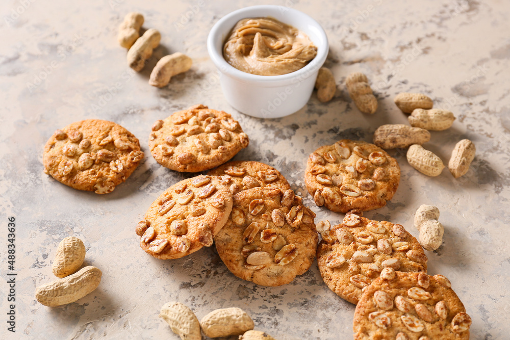 Tasty peanut cookies and butter on beige background