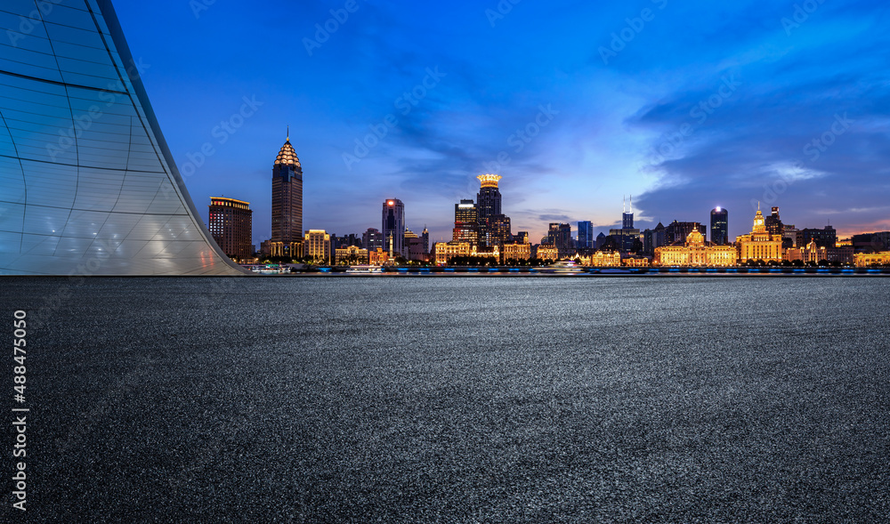 中国上海夜晚的柏油路和城市天际线，以及现代化的商业建筑。