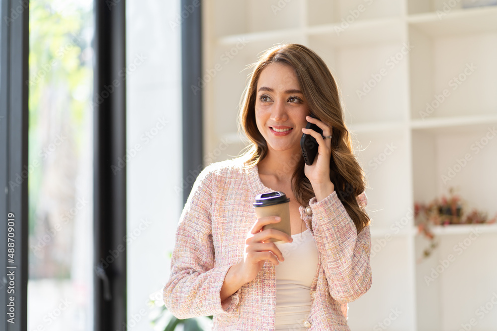 Business woman sit at desk in home office browse surf internet on smartphone drink coffee enjoy morn