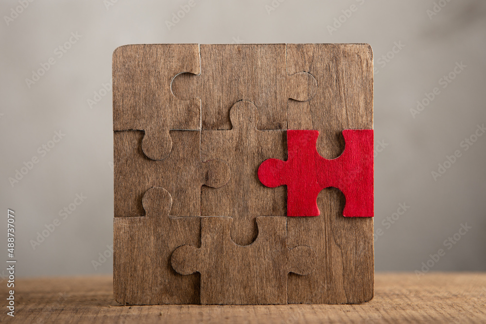 Creative idea and solve the problem concept. Teamwork success strategy - wooden puzzle on the grey b