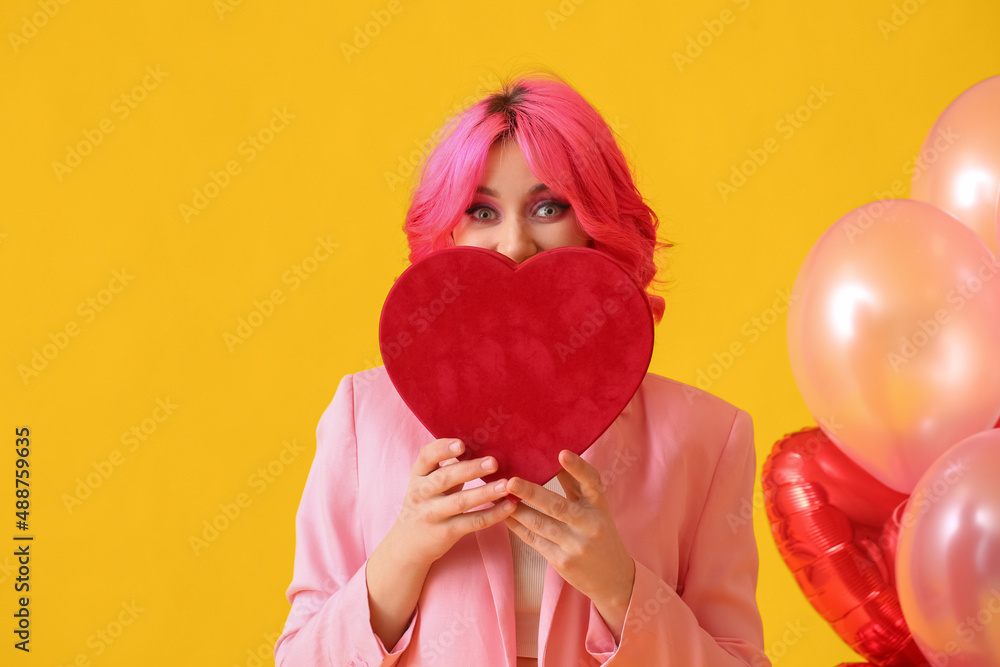 Stylish woman with bright hair, gift and air balloons on color background. Valentines Day celebrati