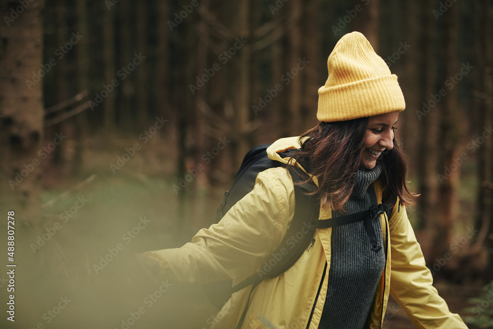 Smiling woman hiking through a forest