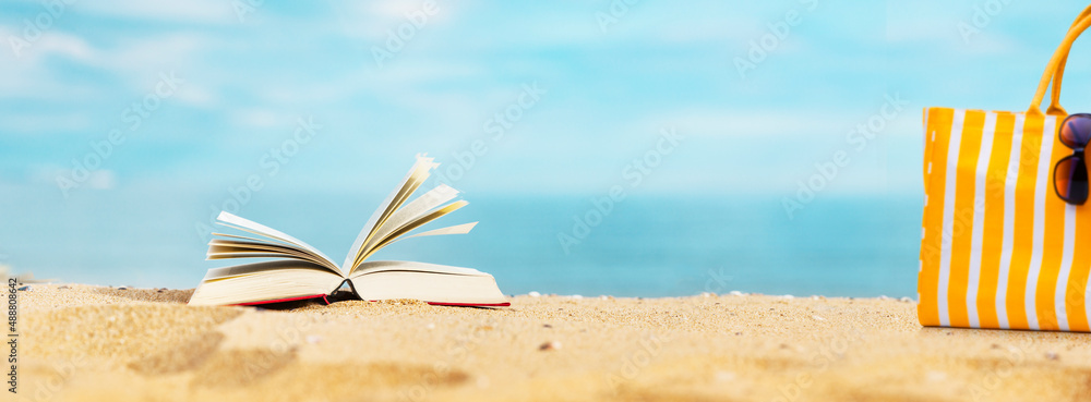 Buch am Sandstrand mit Strandkorb