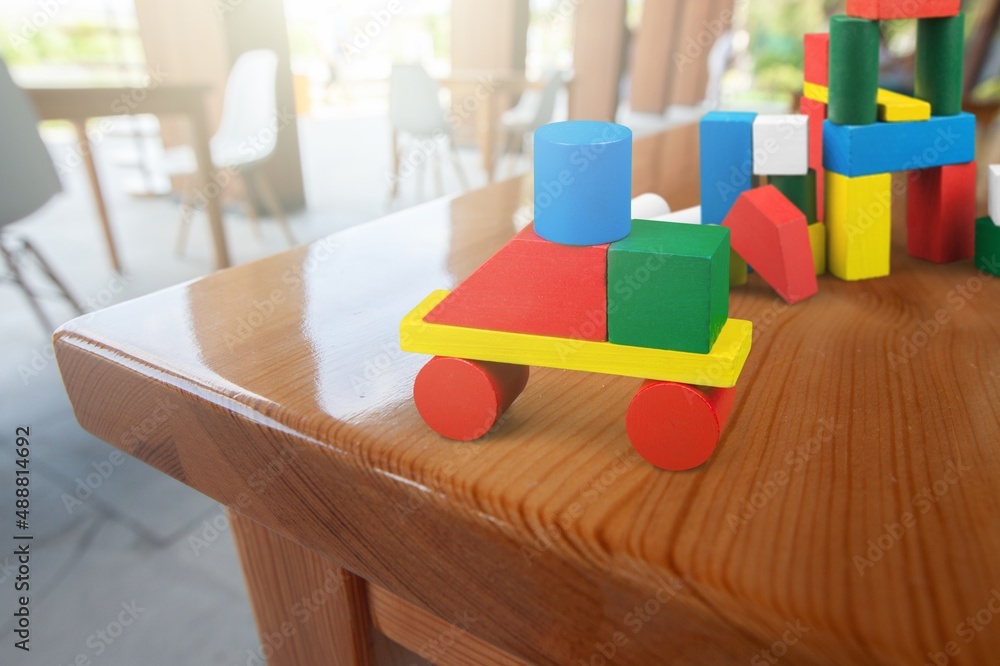 Baby kids toys background. Wooden toy train, wood stacking pyramid tower and colorful wood bricks