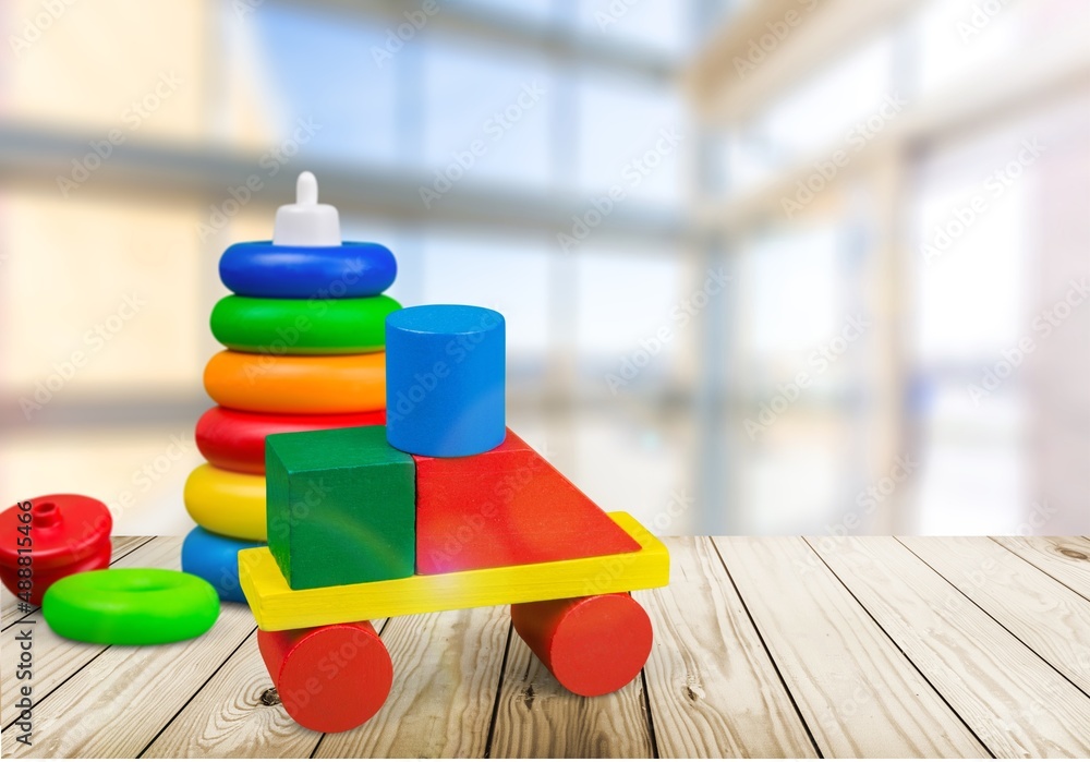 Baby kids toys background. Wooden toy train, wood stacking pyramid tower and colorful wood bricks