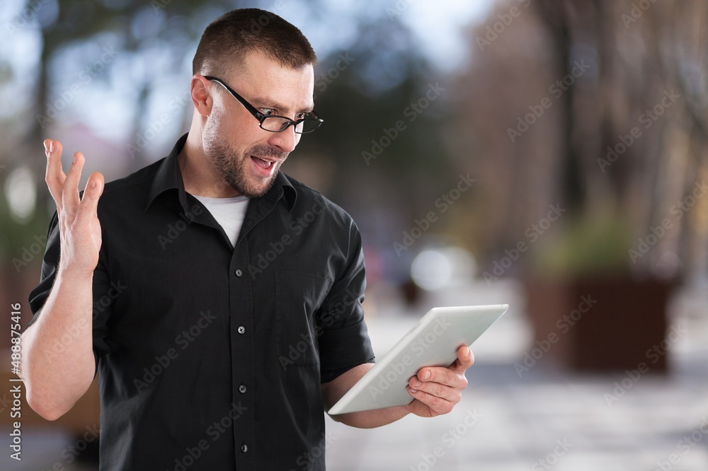 Young student freelancer using digital tablet reading e-book, working remotely, surfing on Internet