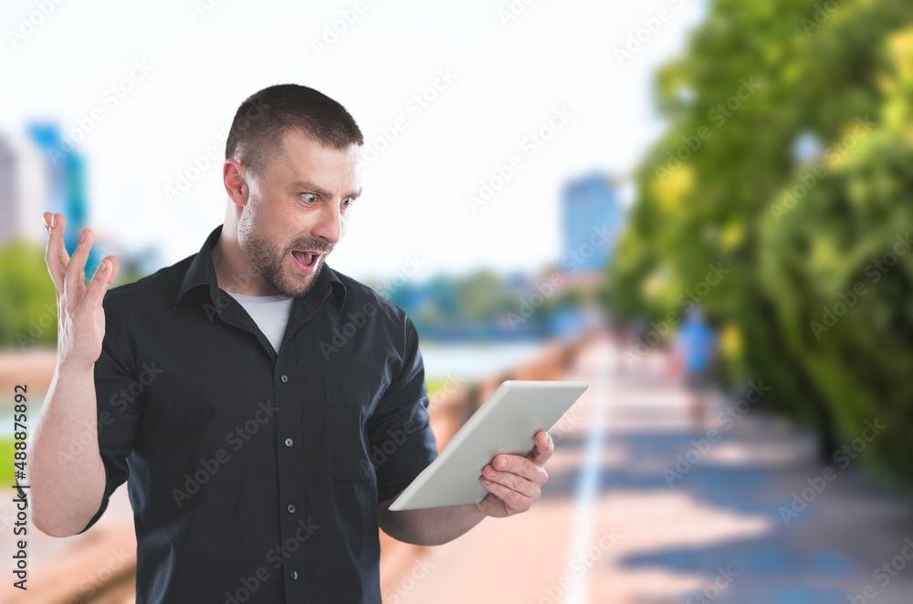 Young student freelancer using digital tablet reading e-book, working remotely, surfing on Internet