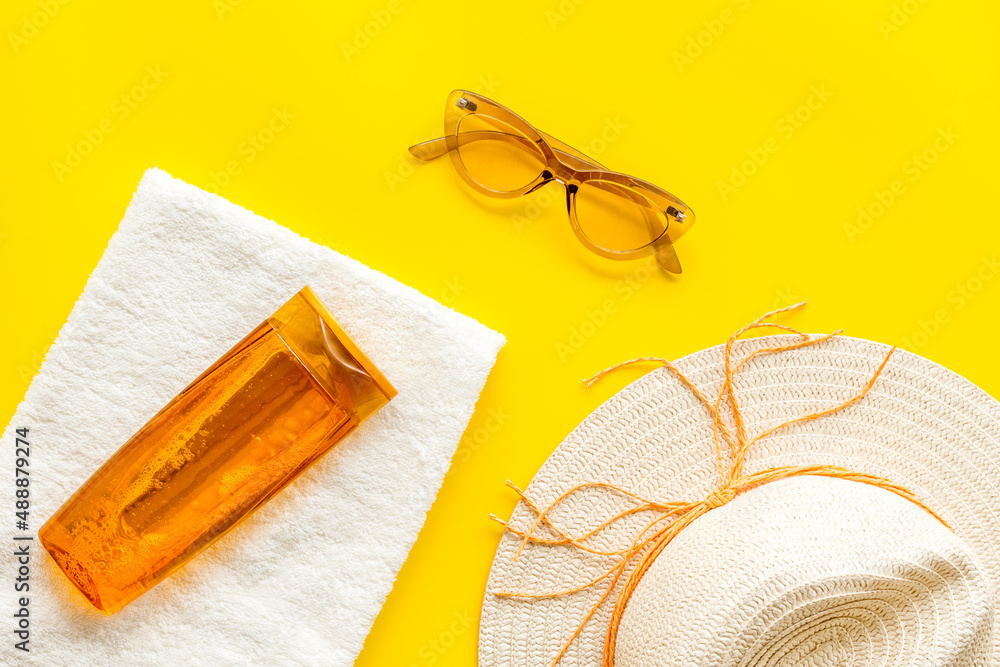 Skin care with sunscreen. Sun lotion and suglasses with straw hat