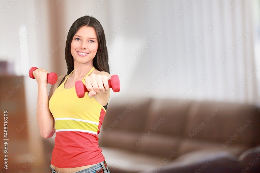 Domestic Training With Weights. Positive lady doing exercises with dumbbells