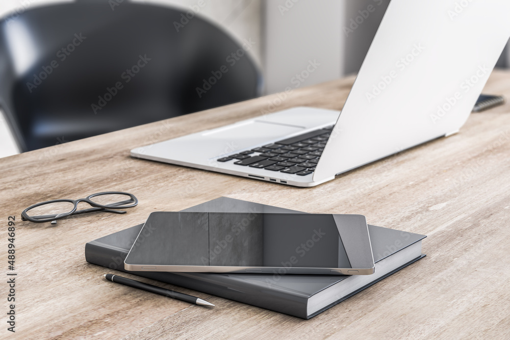 Close up of modern digital tablet on wooden table surface with laptop, notebook and glasses. 3D rend