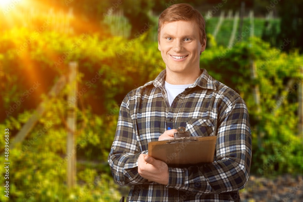 Agronomist inspectin crops growing in the farm field. Agriculture production concept.