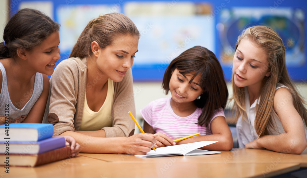 She inspires her students to learn. Shot of a teacher helping her students with their work in the cl