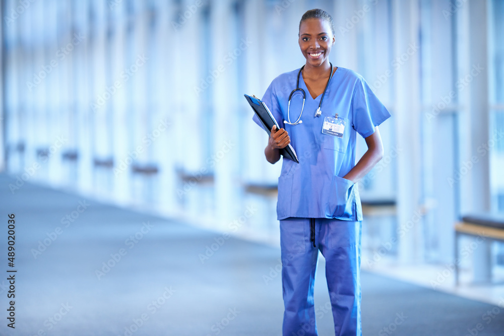 Smiling after surgery. Portrait of a young female doctor holding a patients chart.