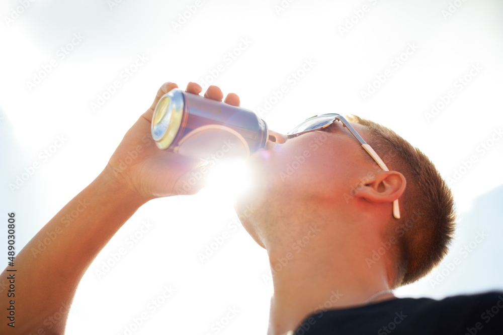 Nothing refreshes better than a cold beer. Closeup of a young man wearing sunglasses drinking a beer