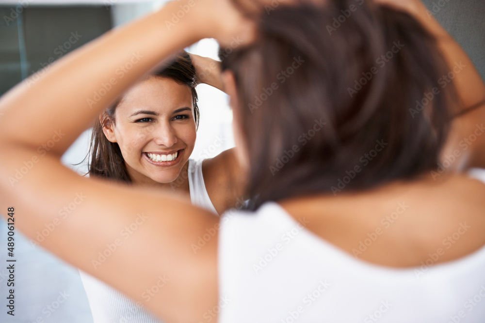 Getting ready is half the funof going out. A cropped shot of a happy young woman deciding on a hair 