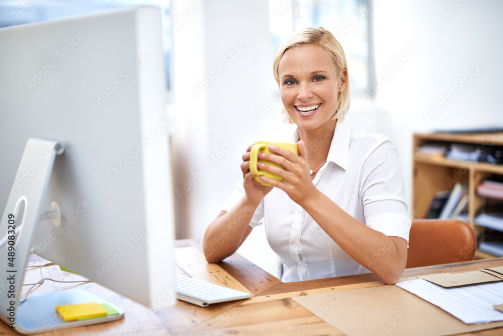 Quick coffee break. Portrait of a young businesswoman drinking coffee at her desk.