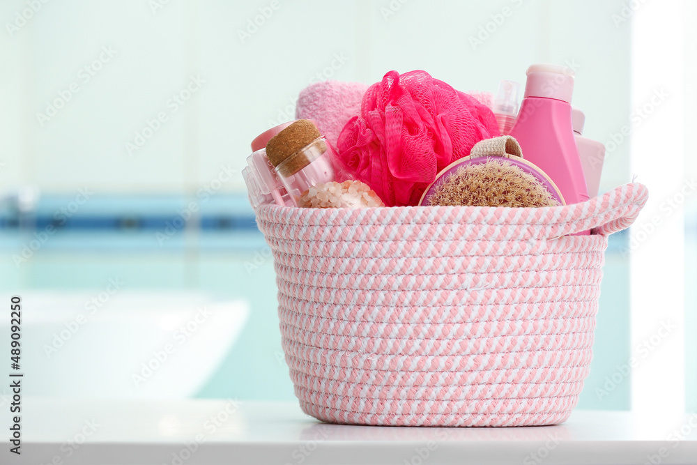 Wicker basket with different bath supplies on table