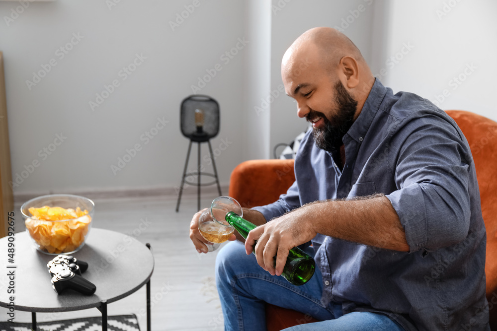 秃头男子在家喝啤酒