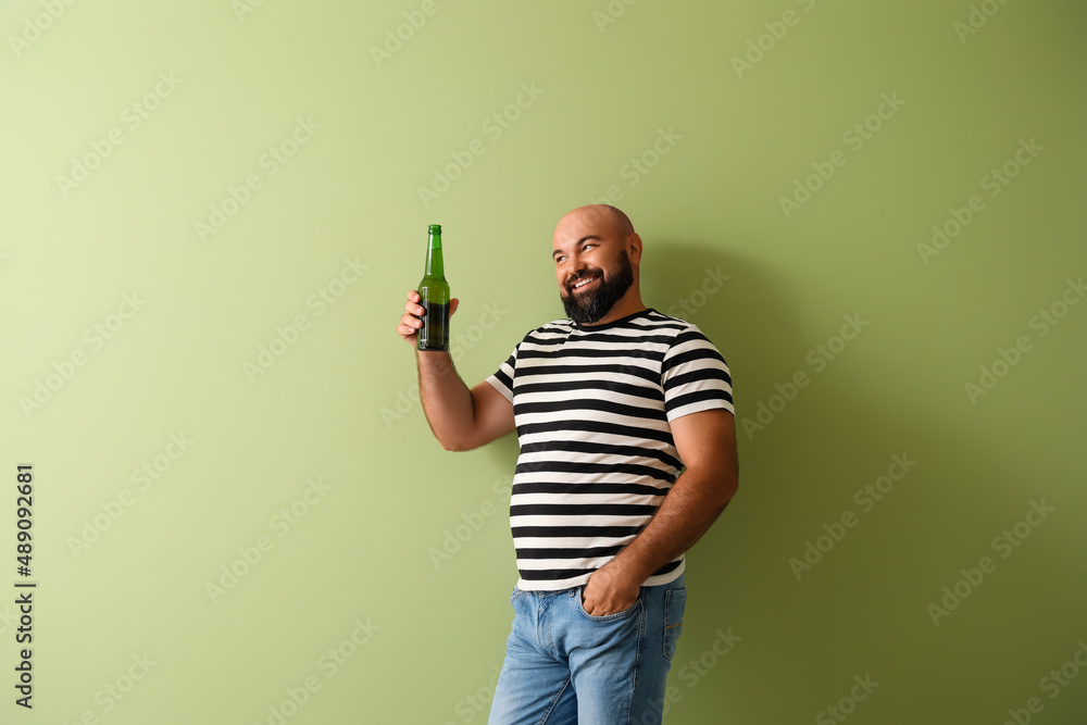 Bald man with beer on color background