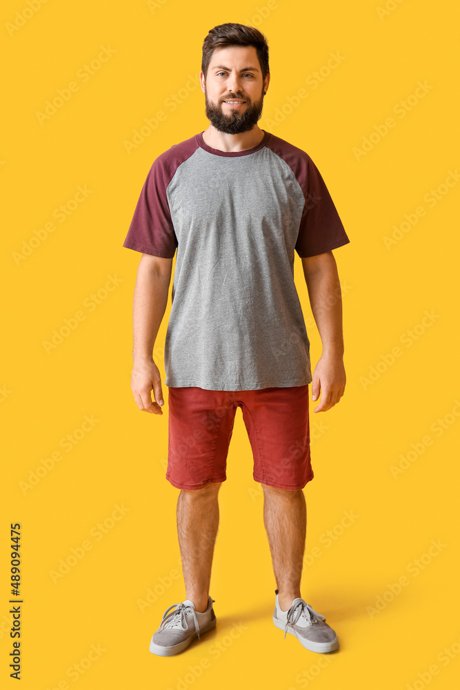 Handsome man in t-shirt on yellow background