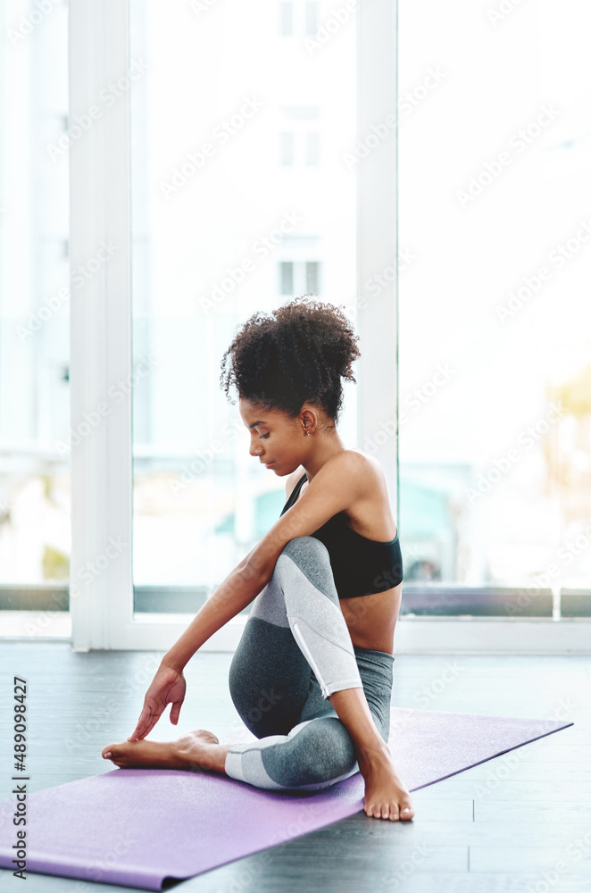 Youre only as good as you want to be. Shot of a beautiful young woman practising yoga in a studio.