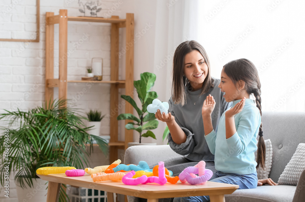 Little girl and her mother playing with Pop Tubes at home