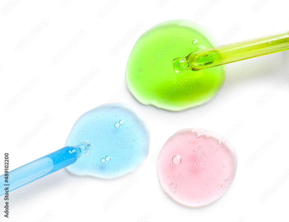 Glass droppers and sample of cosmetic serum on white background