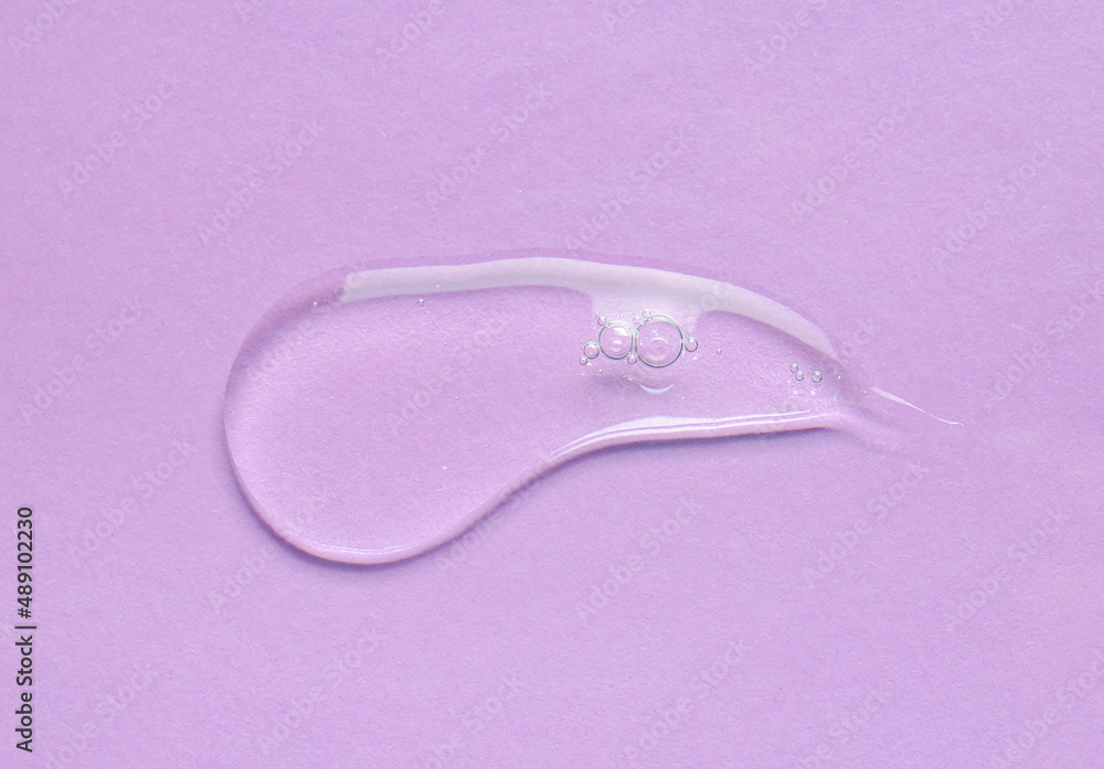 Sample of cosmetic serum on color background