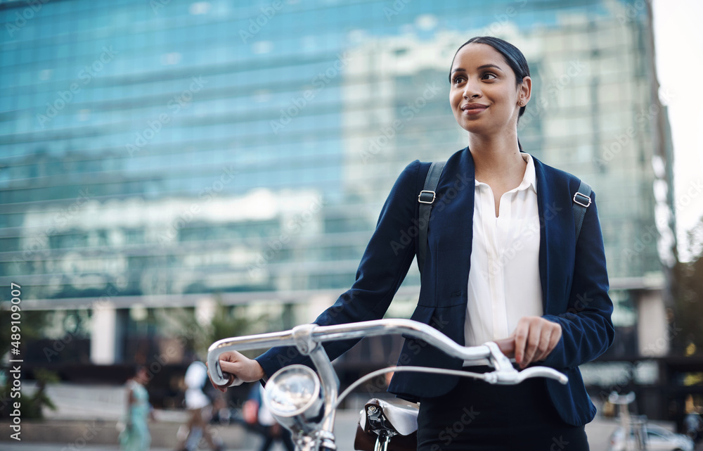 Welcome to the city, where opportunity awaits. Shot of a young businesswoman traveling with a bicycl