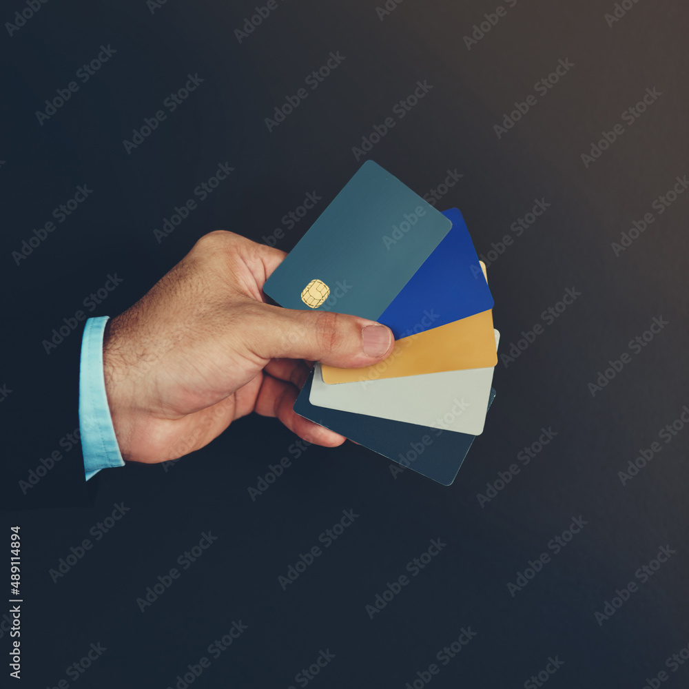 Swipe any of them. Studio shot of an unidentifiable businessman holding a selection of credit cards 