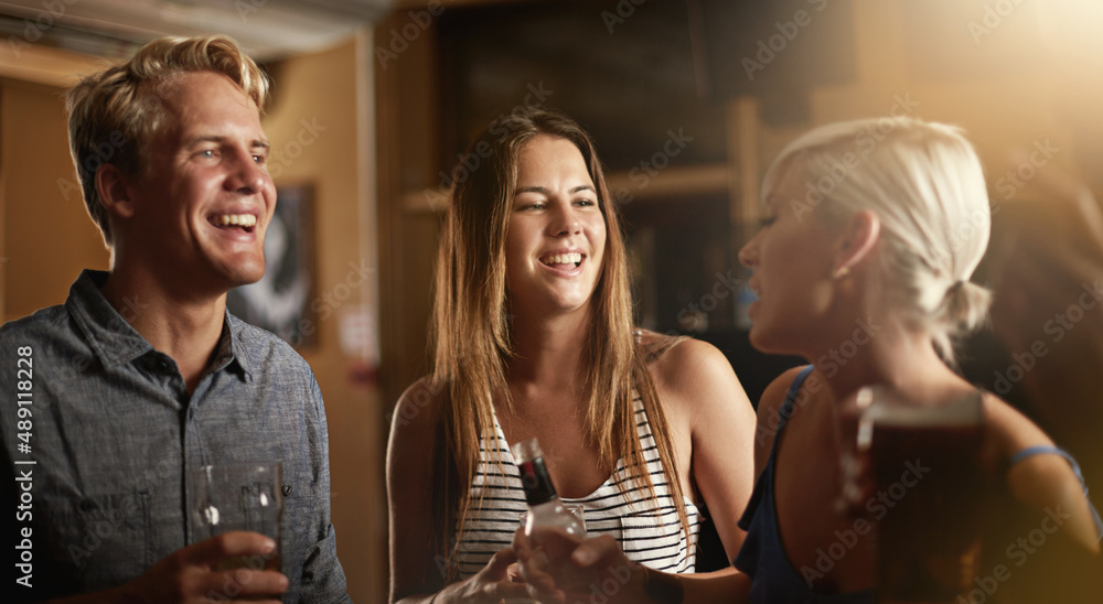 Enjoying a fun-filled evening with friends. Shot of a group of friends enjoying themselves in the ba