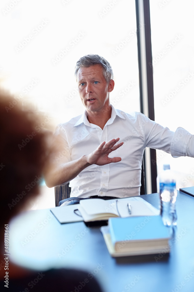 We need to take this to a new direction. Shot of two colleagues having a discussion in the office.